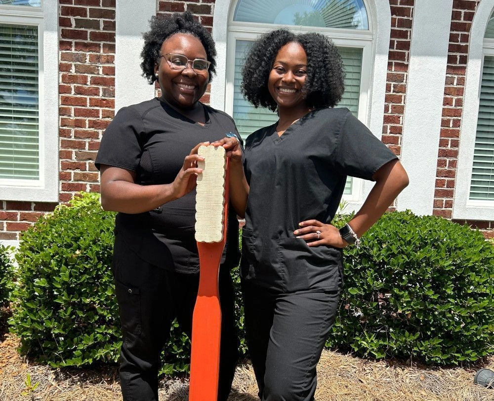 students posing with life size toothbrush outside of the facility students posing with life size toothbrush outside of the facility